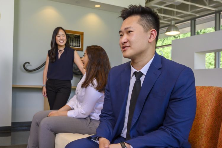 Three PharmD students in the student lounge in the Chan Family Health Sciences Learning Center and Clinics