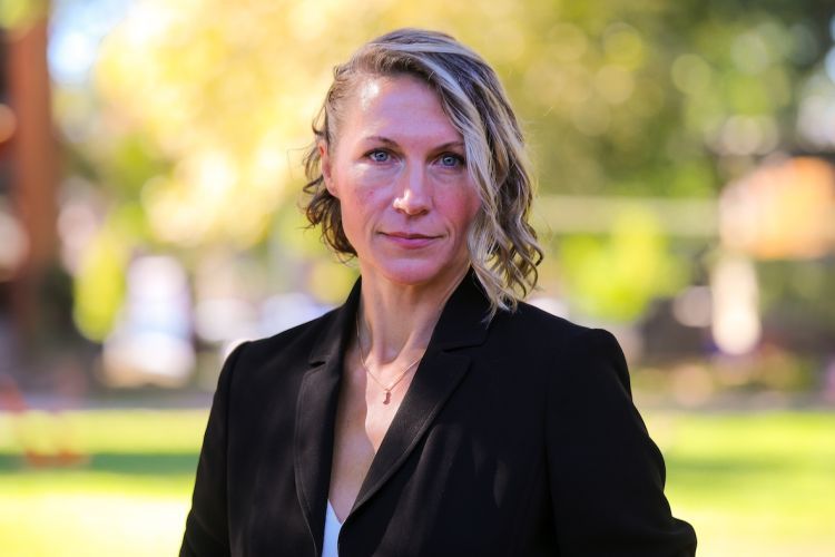 Woman in black blazer talks a headshot