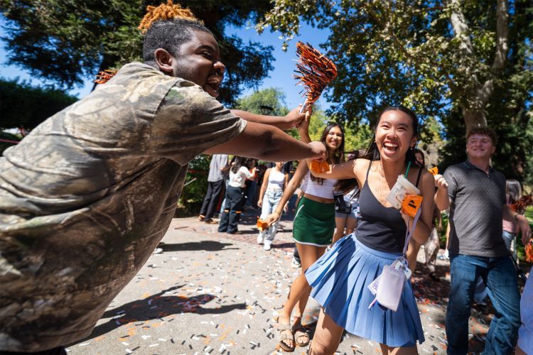 students cheer while walking through campus