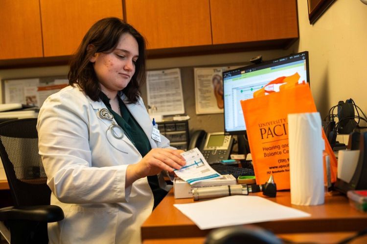an audiology student sits at a desk