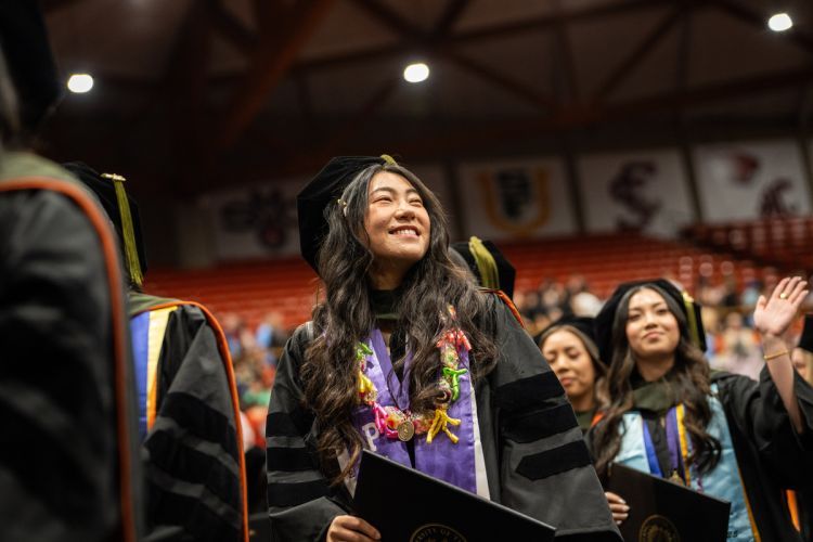 A student wears a cap and gown at commencement