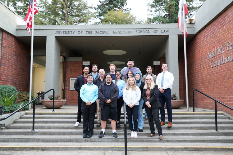 Two professors pose for a photo with 12 students from the Elder and Health Law Clinic in 2023.