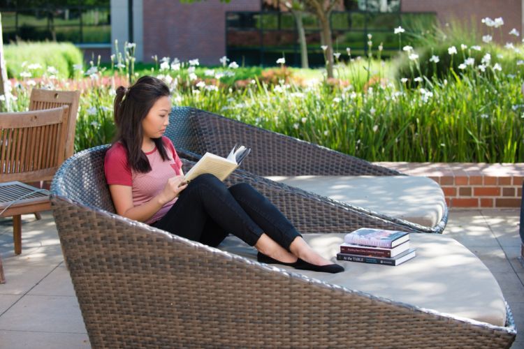 Student reading on the DeRosa University Center patio.