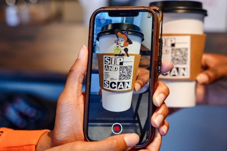 Students scan the QR code on the coffee cup to view the project.