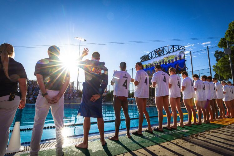 Waterpolo athletes stand next to the pool