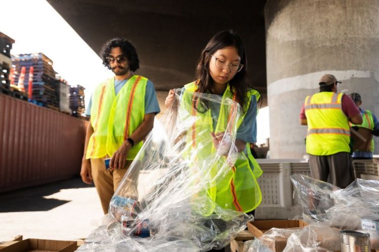 Student cleaning up trash in yellow vests