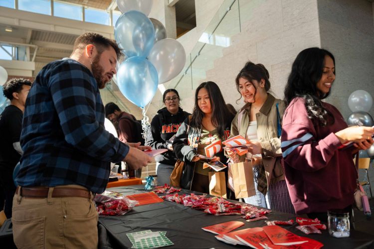 Students at a table receiving flyers 