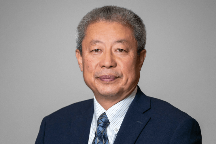 Li smiling in a black suit 