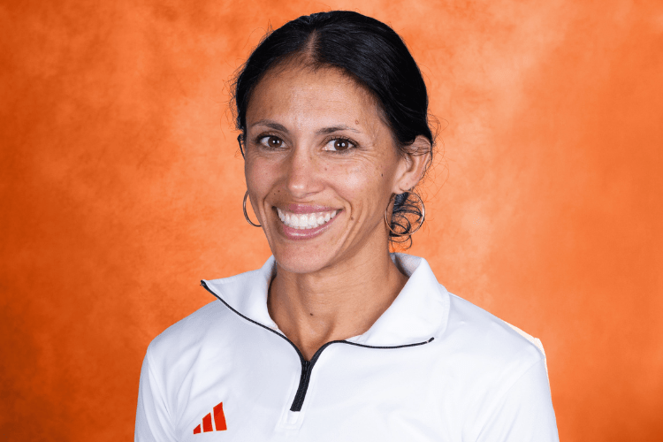 Cherise Roberts smiling in front of an orange backrop