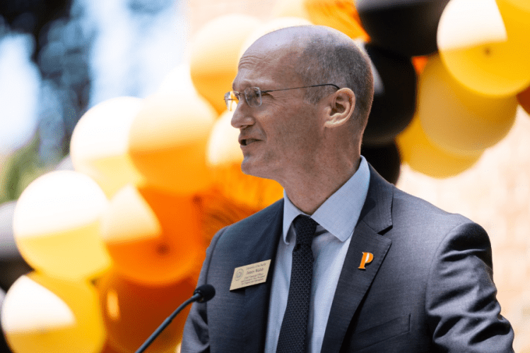 James Walsh stands in front of balloons as he makes a speech