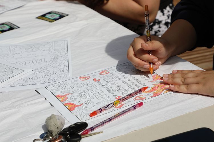 An overhead image of a person coloring a coloring sheet. 