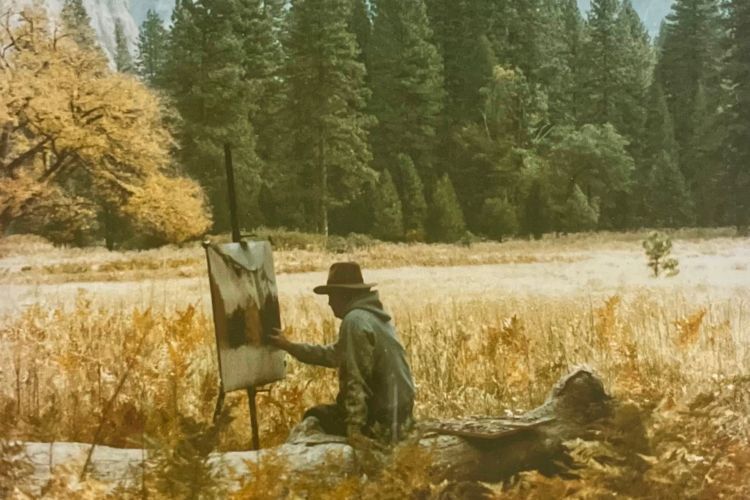 Gil painting a landscape outdoors from afar. 