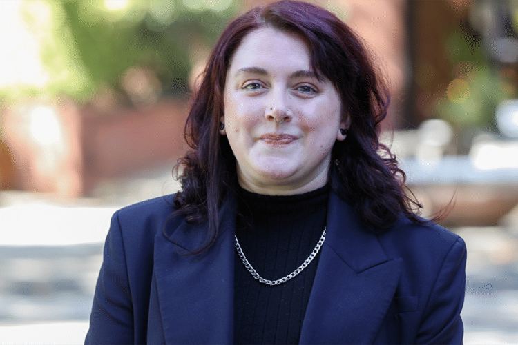 A women with red hair stands for a professional photo. 