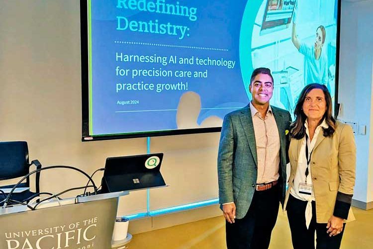 man and woman standing side by side in front of a screen projecting a presentation titled Redefining Dentistry