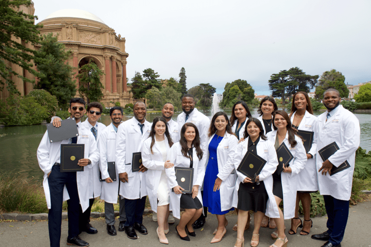 students in white coats posed in front of Palace of Fine Arts