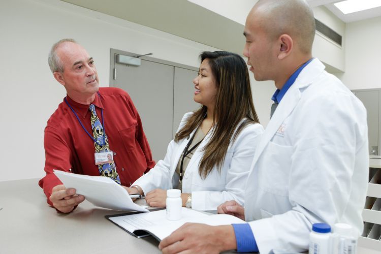 Two PharmD students with faculty member David Collum