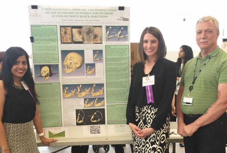 Students Robin Lambert and Riddhima Suri, members of the DDS Class of 2017, along with their faculty advisor Dr. Gary D. Richards, pose with the poster for their project, "A New Insertion Landmark and Modification of the 'Standard Technique' for Inferior Alveolar Nerve Block Injections".