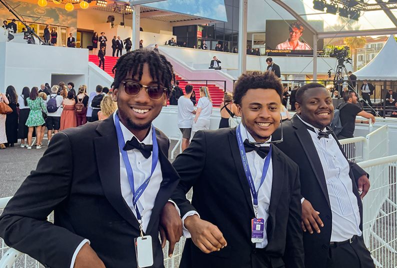 Three students pose for a picture at Cannes Film Festival