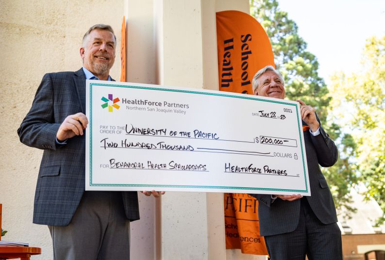 paul lanning and christopher callahan holding check at presentation