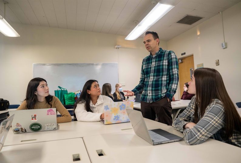 a professor works with a group of students