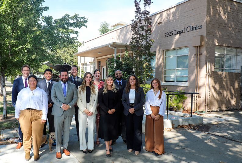 A group of 11 people posing in front of the clinic building