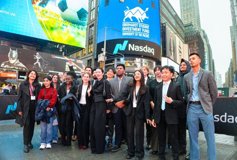 Students post in front of NASDAQ