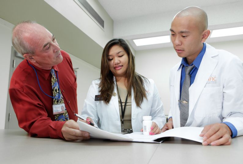 Two PharmD students with faculty member David Collum