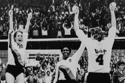 Volleyball players celebrate a win on the court