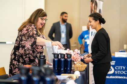 an employer and student speak at a career fair booth