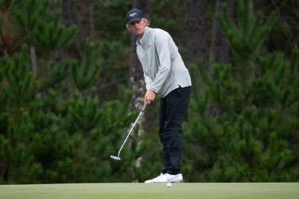 a student stands on a golf course