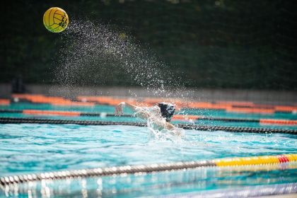 a water polo player throws a ball in the pool