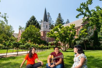 students sit on the lawn in front of the methodist church