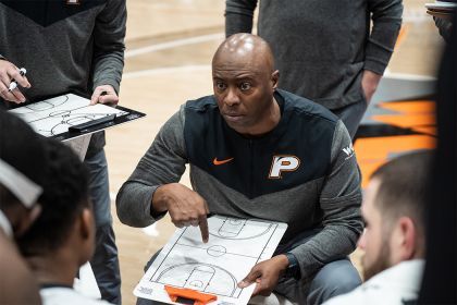 Leonard Perry talks to his players on the court