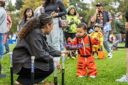 A child dressed up as an astronaut gets candy during Pacific Trick or Treat