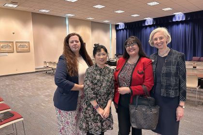 Four women pose for a photo indoors