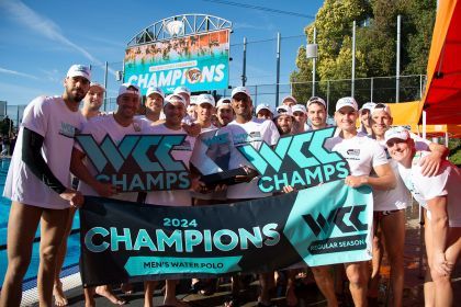 students pose for a picture holding a championship banner