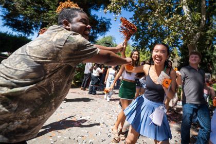 students cheer while walking through campus