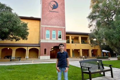 Student Ethan Fontes stands in front of a building that has a "DreamWorks" sign on it.