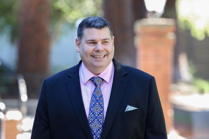 A portrait of a man wearing a suit outdoors