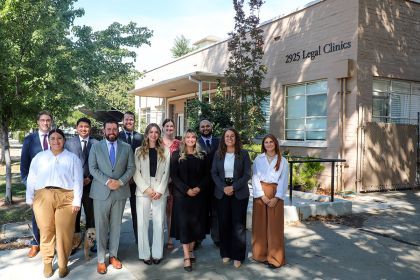 A group of 11 people posing in front of the clinic building