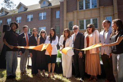 University and state leader cut an orange ribbon outside of Southwest Hall.
