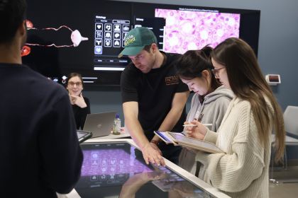 Physician Assistant students working with an anatomage table.