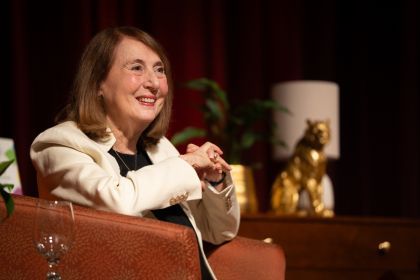 Cathy smiles in a beige blazer 