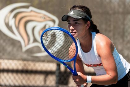 Indiya McLeod ’27 holds a tennis racket and prepares to hit the ball.