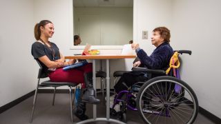student talking to woman in wheelchair