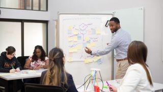 students interact with professor in classroom