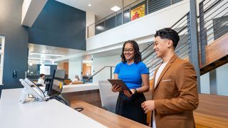 Two hospitality specialists at a reception desk 