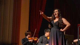Senior music performance major sings on stage with an orchestra