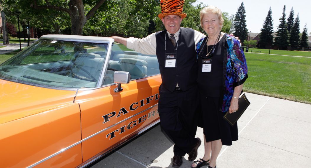 Alumni posing with Pacific car