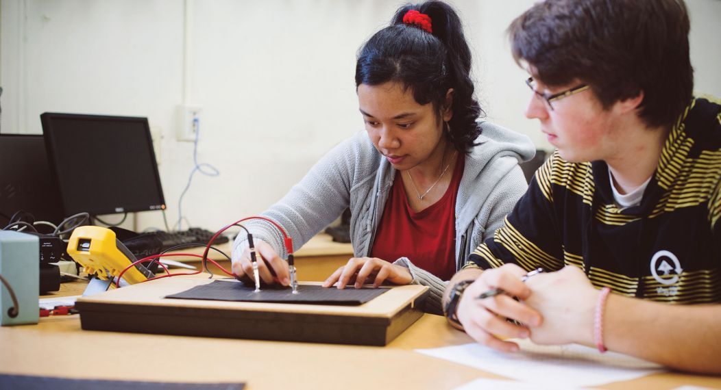 Physics students working with electrodes